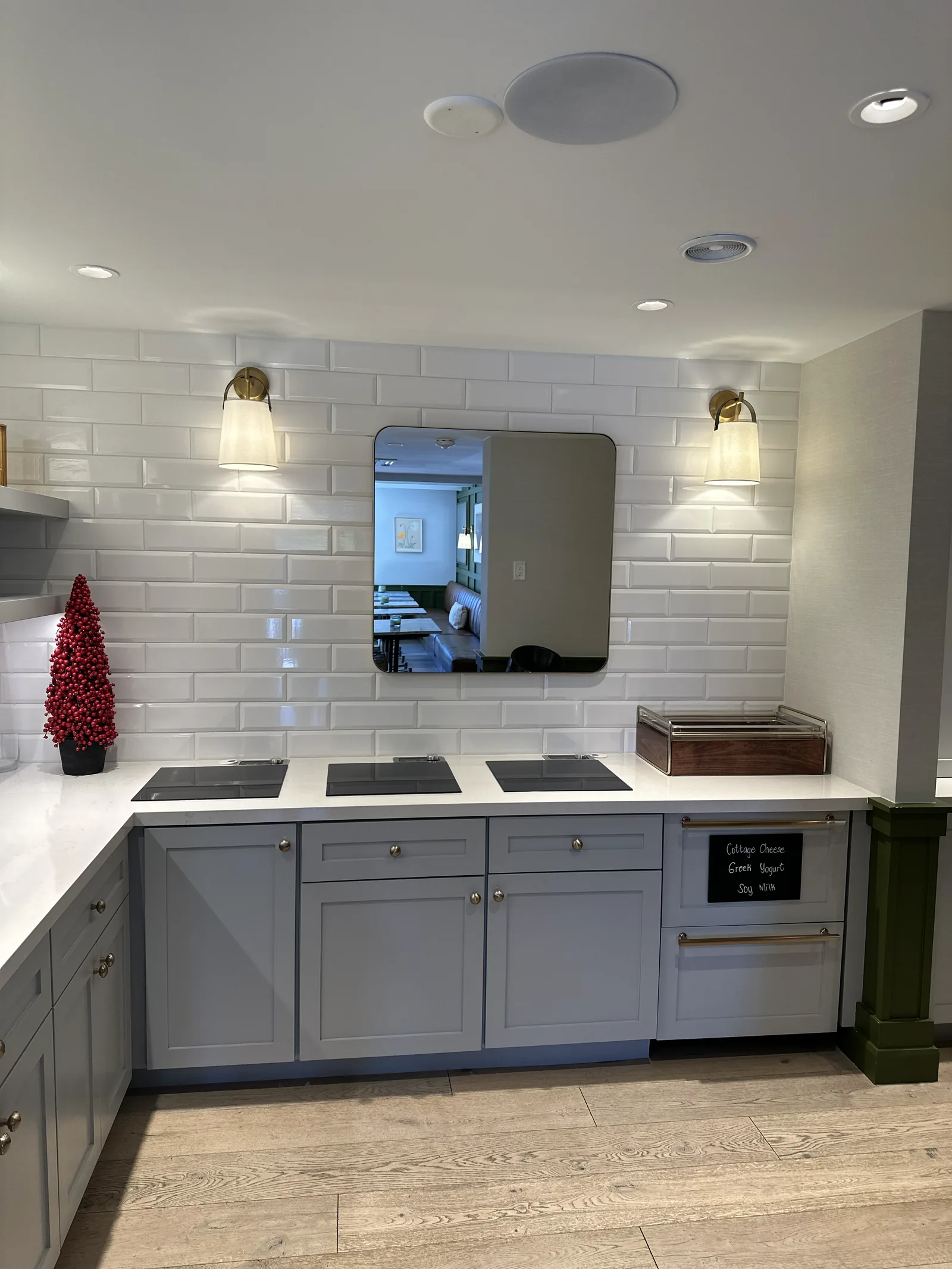 Grey commercial kitchenette with subway tile and wall sconces in Atherton