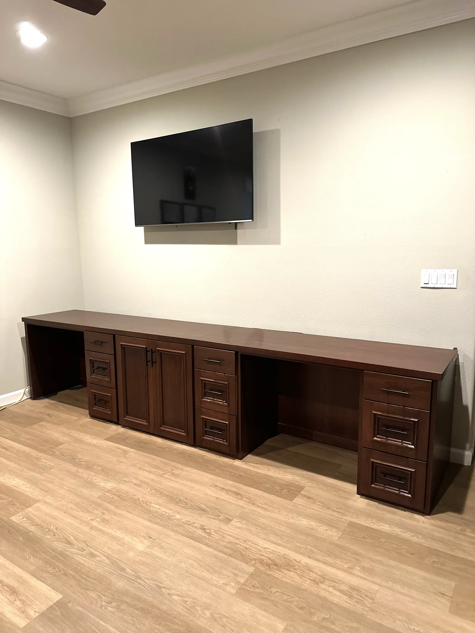 Dark stained built-in home office desk run with an integrated display in Gilroy