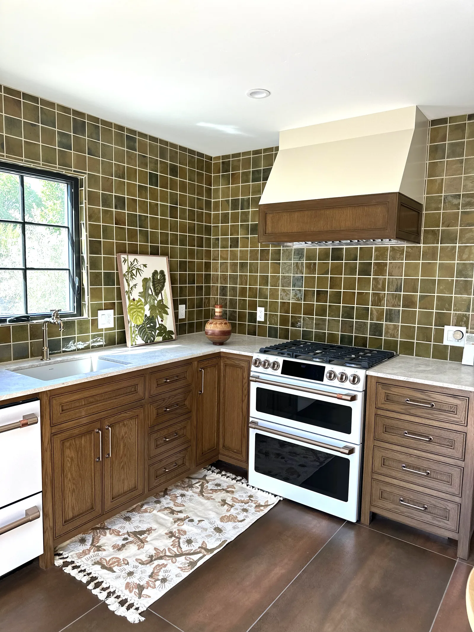 White oak kitchen with an olive green tile backsplash and wood hood in Gilroy