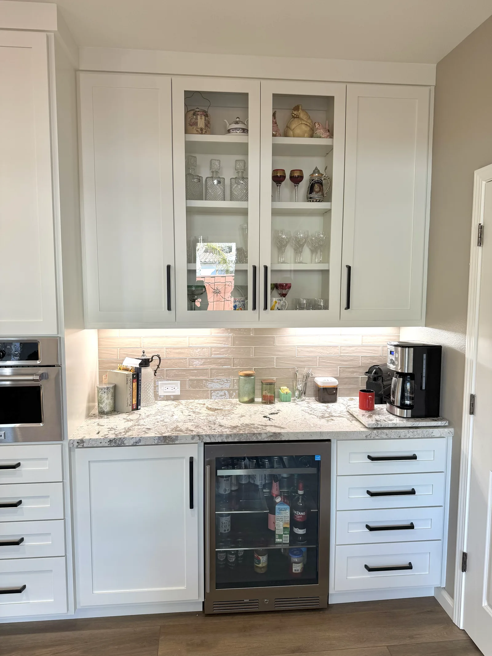 White shaker beverage bar with glass front uppers and a wine fridge in Gilroy