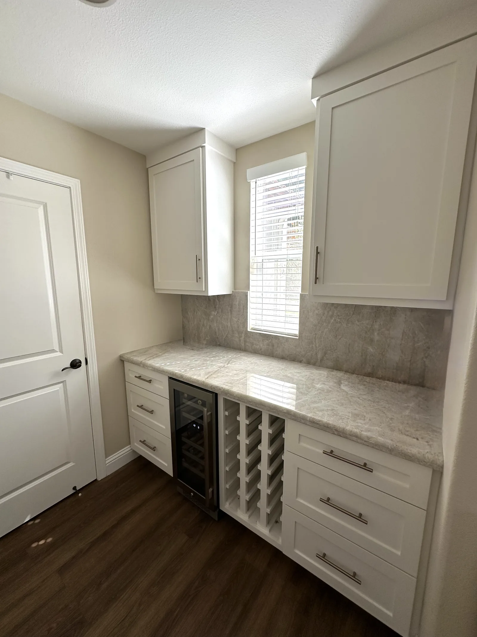 White shaker butler pantry with a wine rack and built-in beverage fridge in Gilroy