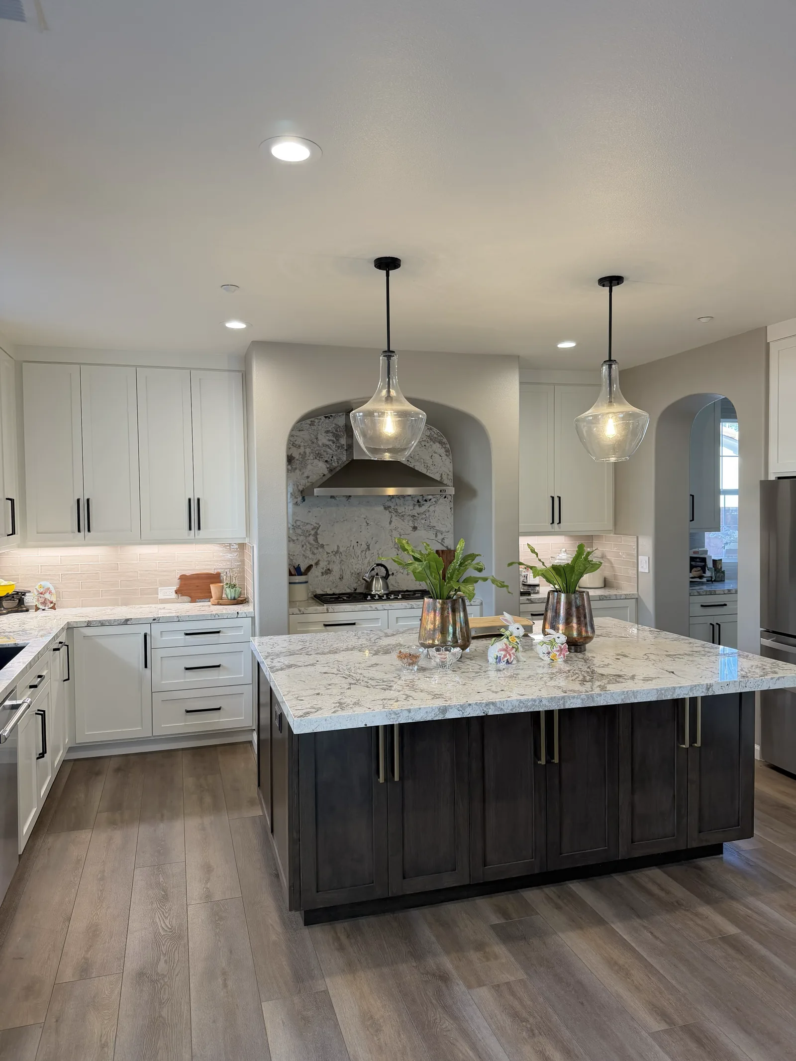 White shaker kitchen with a dark stained island and granite counters in Gilroy