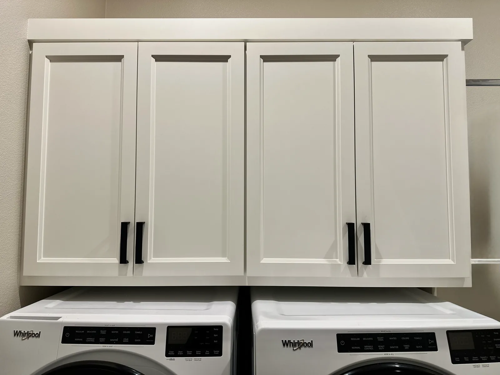 White shaker laundry uppers mounted above a washer and dryer in Hollister