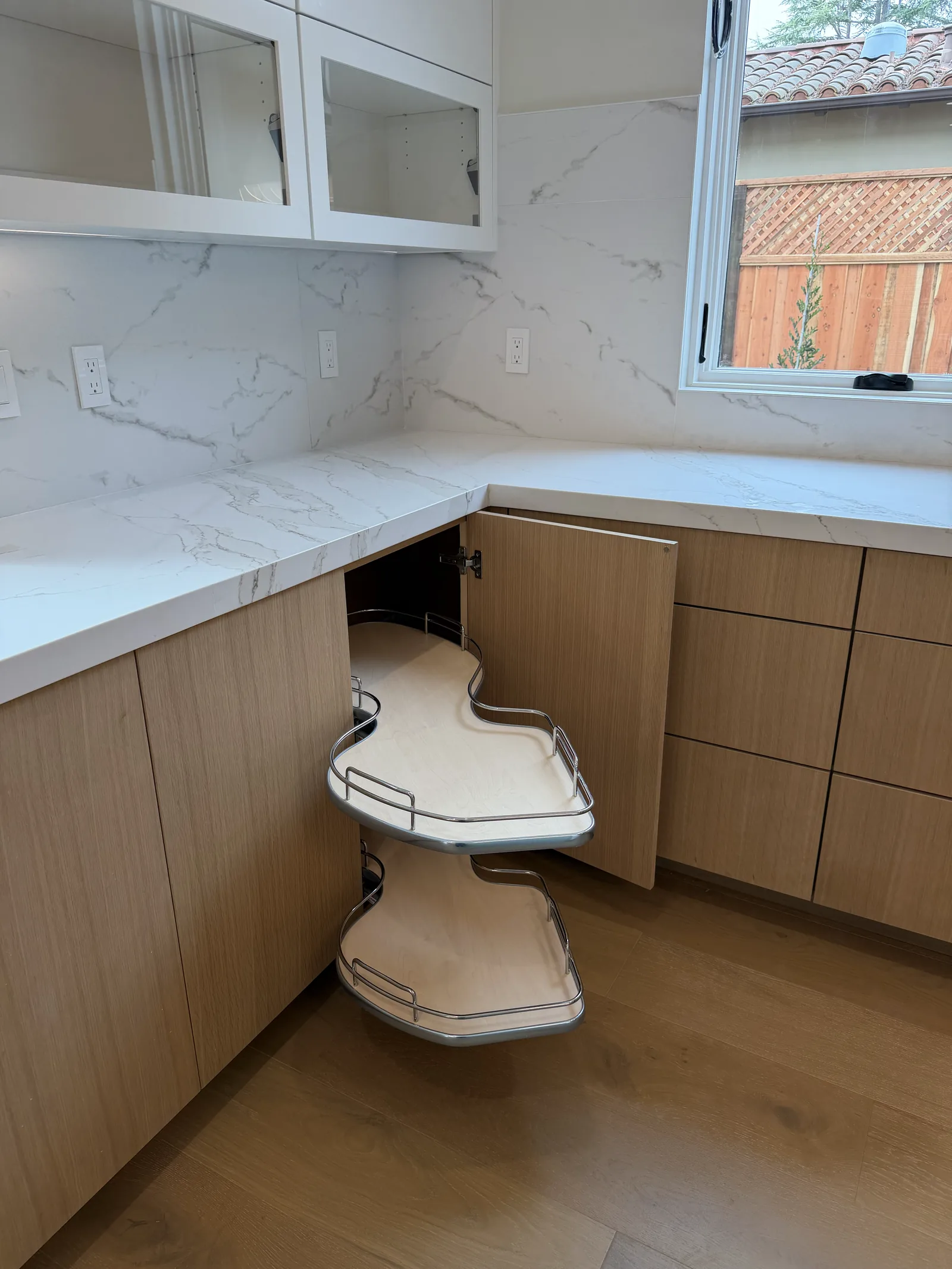 Blind corner pull-out unit swinging clear of a white oak cabinet in Los Altos