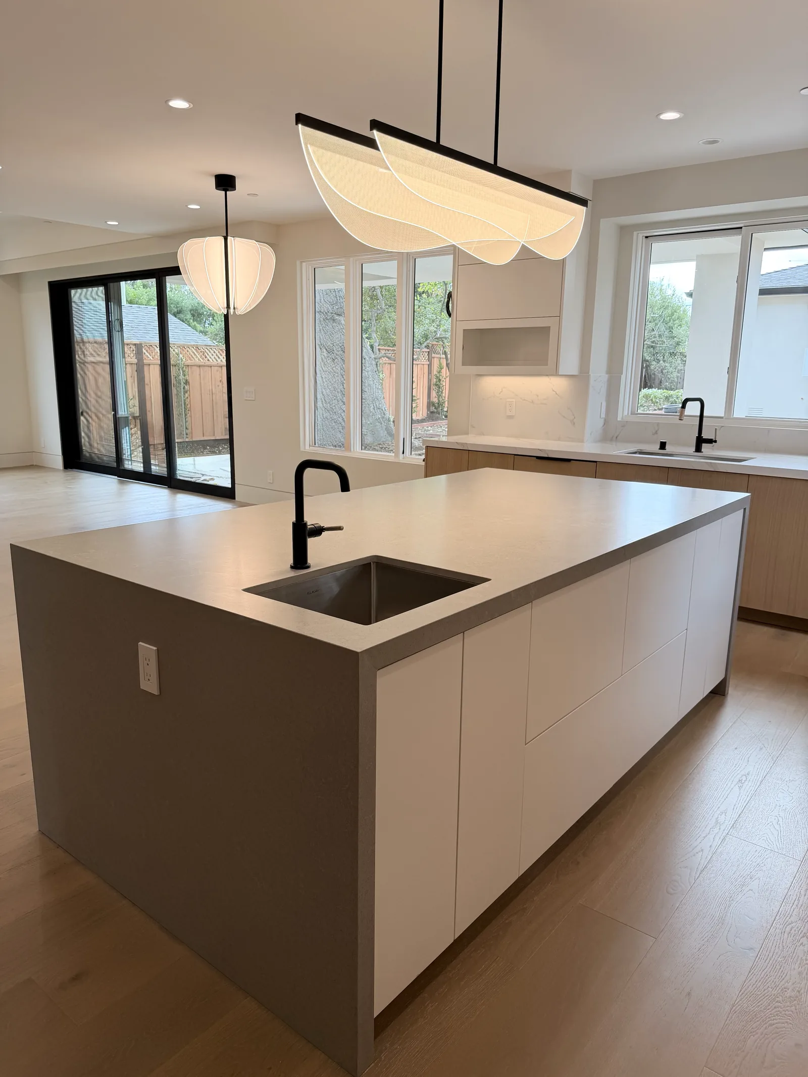 Modern kitchen island with a waterfall quartz top and matte black tap in Los Altos