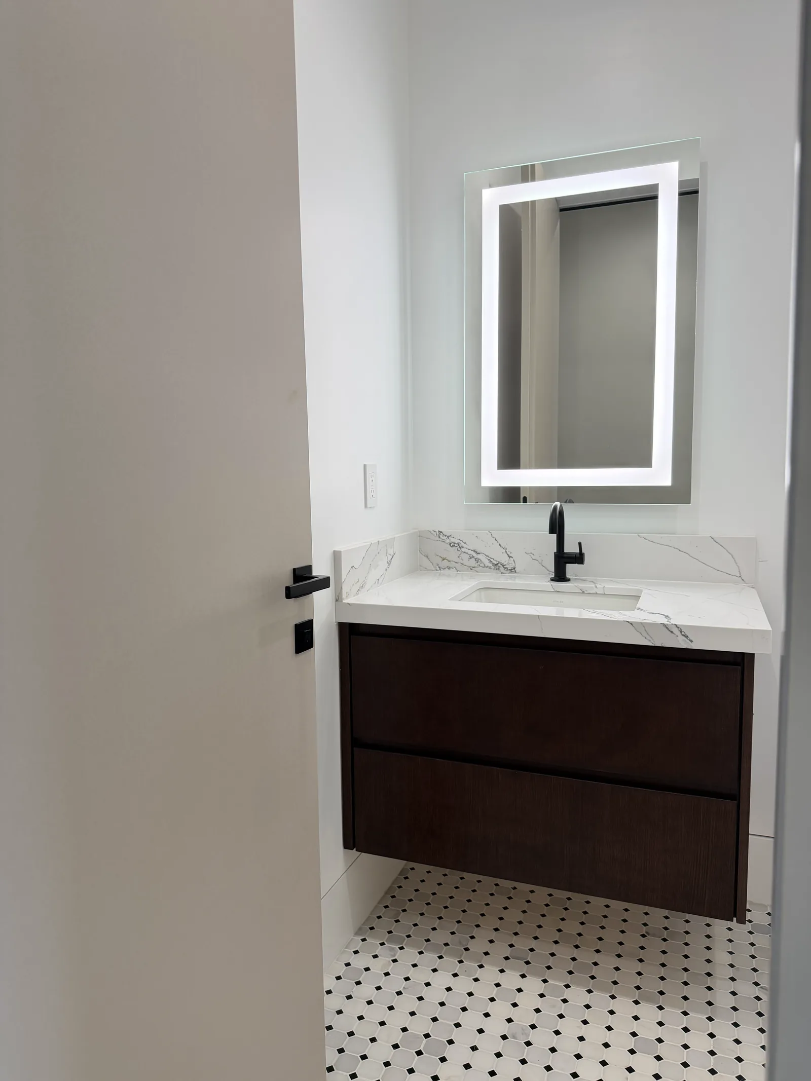 Dark walnut floating vanity with marble quartz and penny tile floor in Los Altos