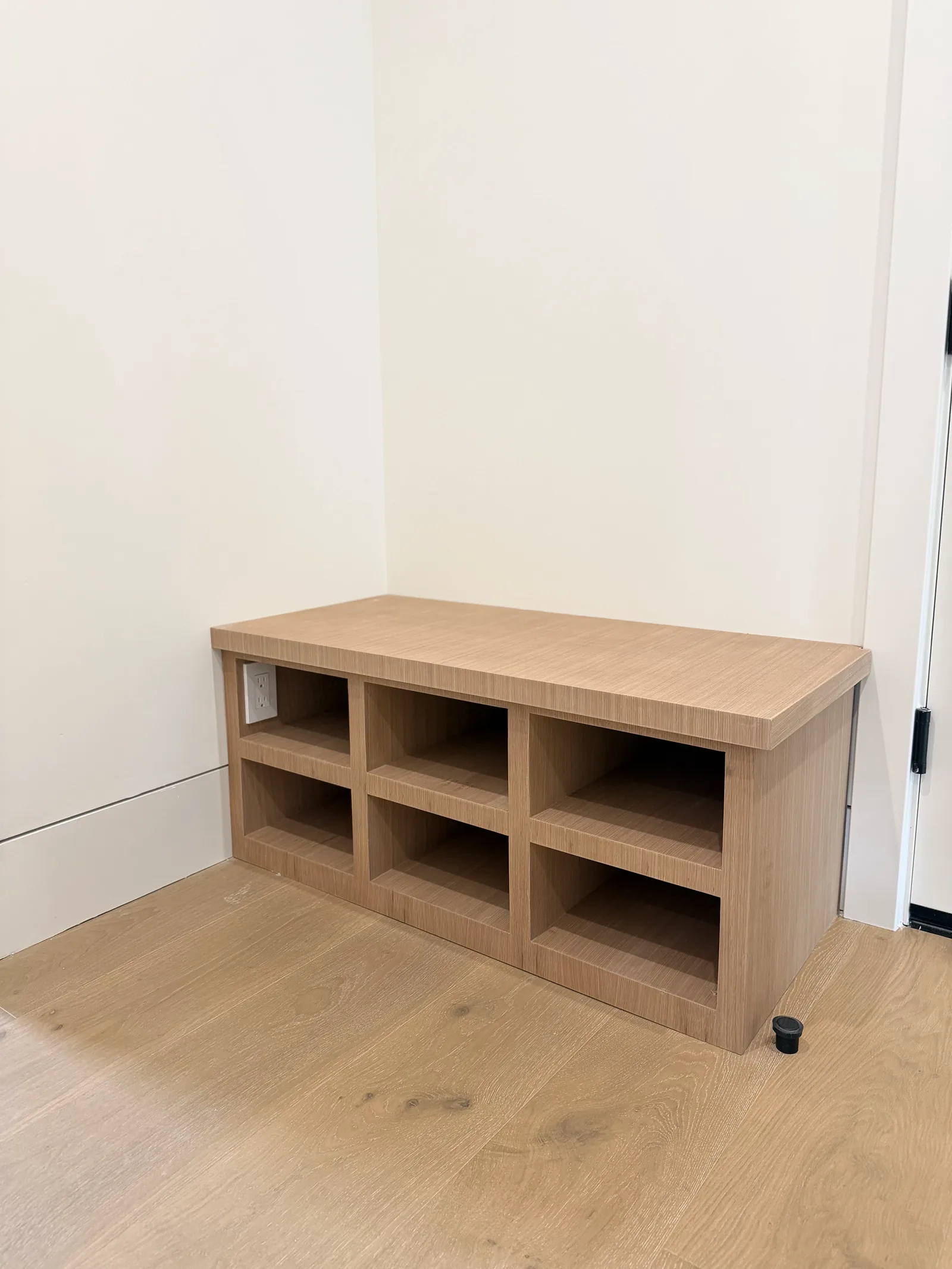 White oak entry bench with open cubby storage underneath in Los Altos