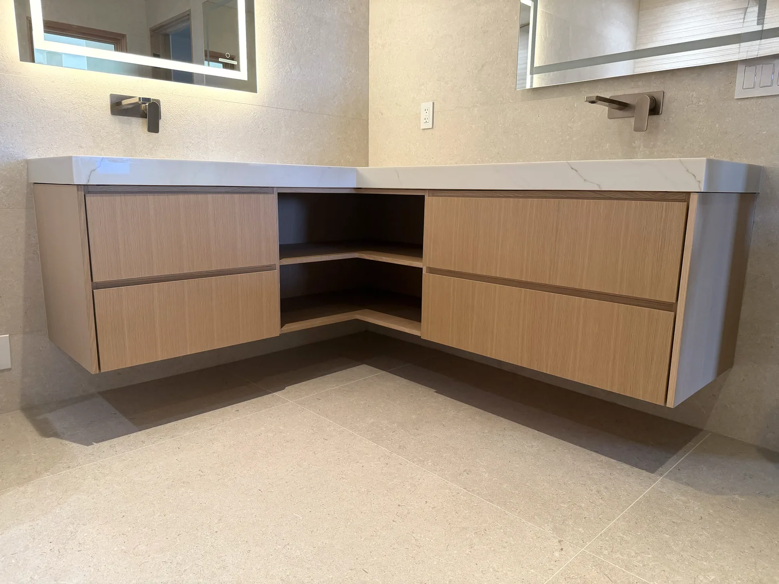 White oak floating corner vanity with a waterfall quartz top in Monterey