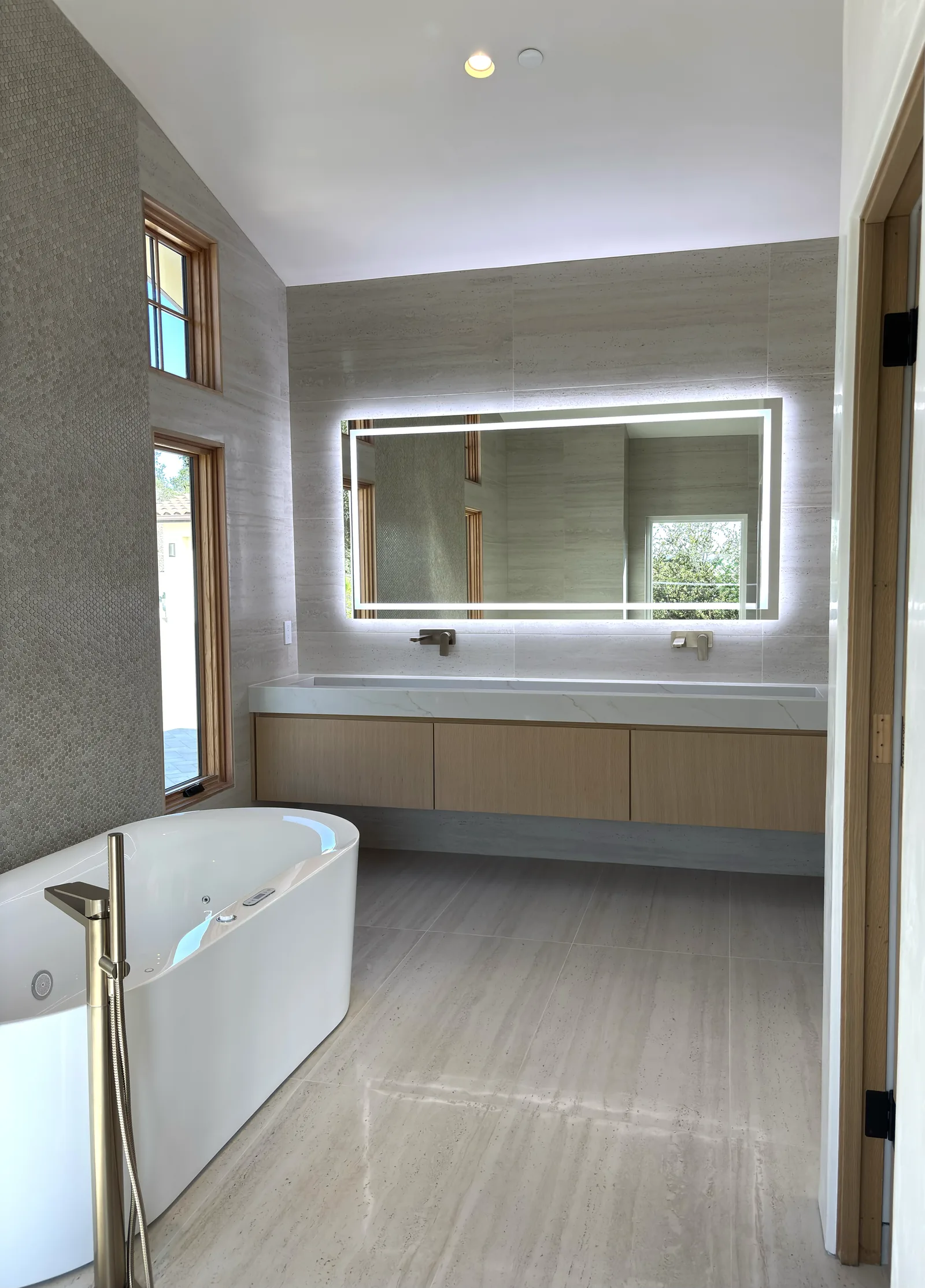 White oak vanity run beside a freestanding tub in a Monterey bathroom