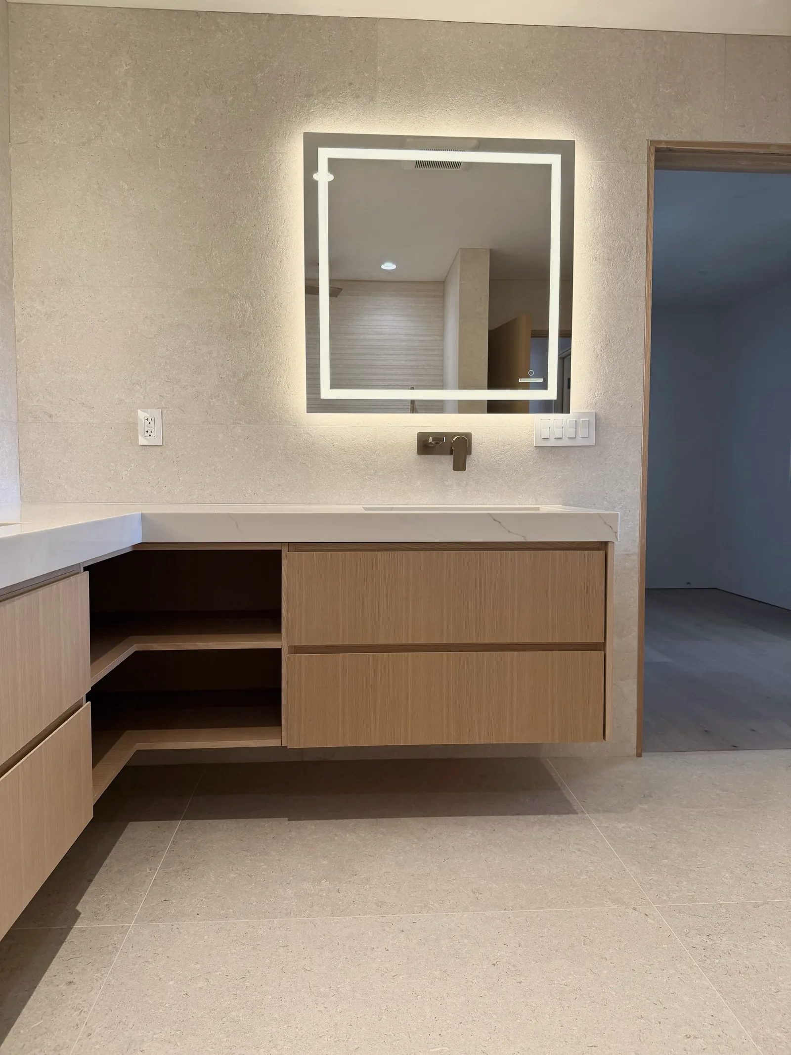 White oak floating vanity with an open shelf below the basin in Monterey