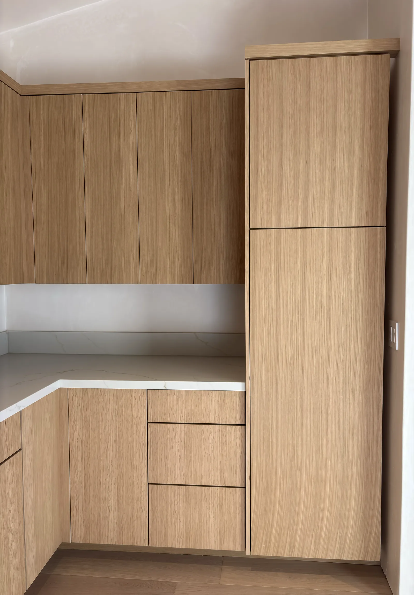 Full height white oak wardrobe cabinets built into a Monterey bedroom