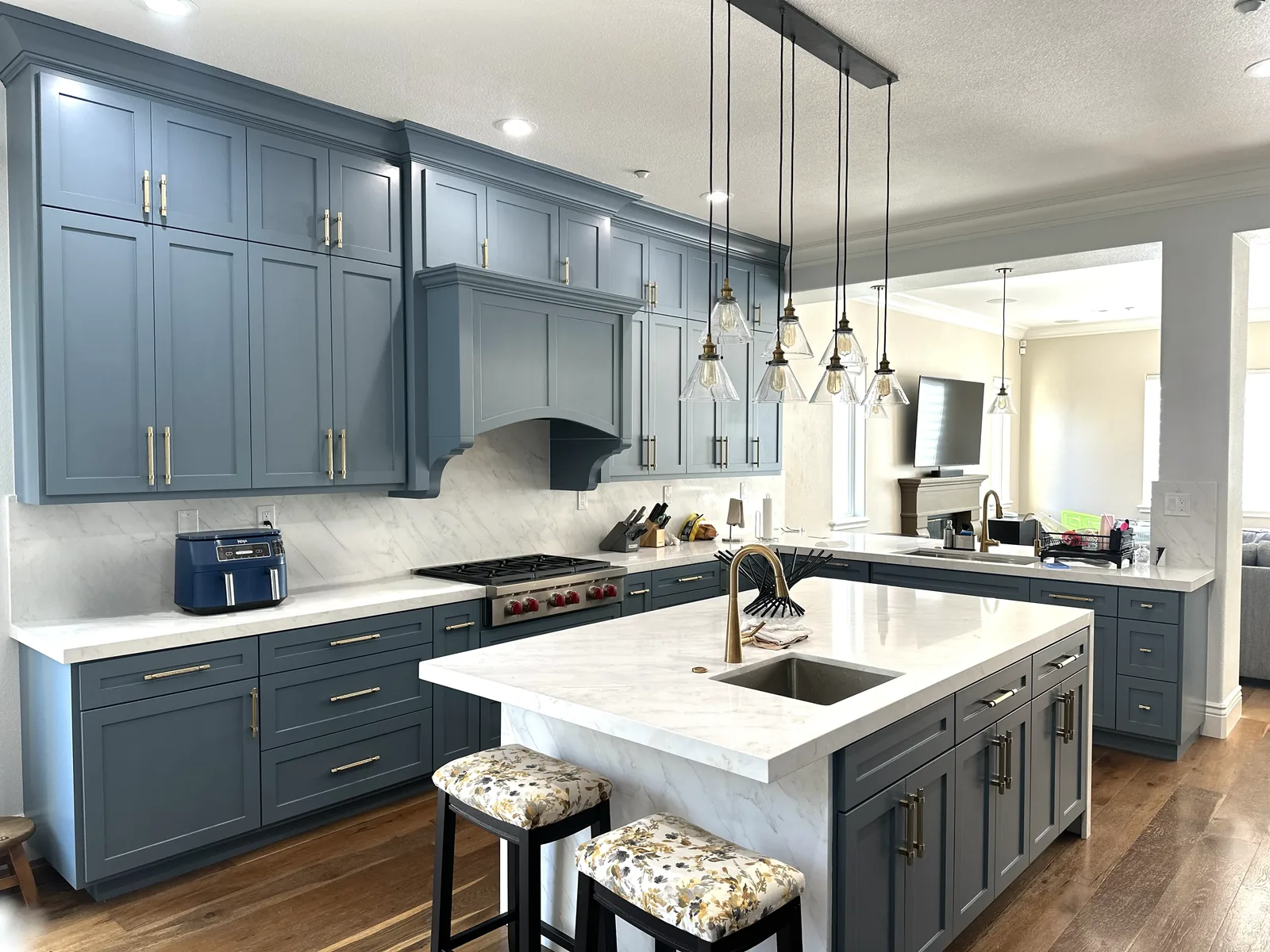 Blue grey shaker kitchen with marble counters and brass hardware in Morgan Hill