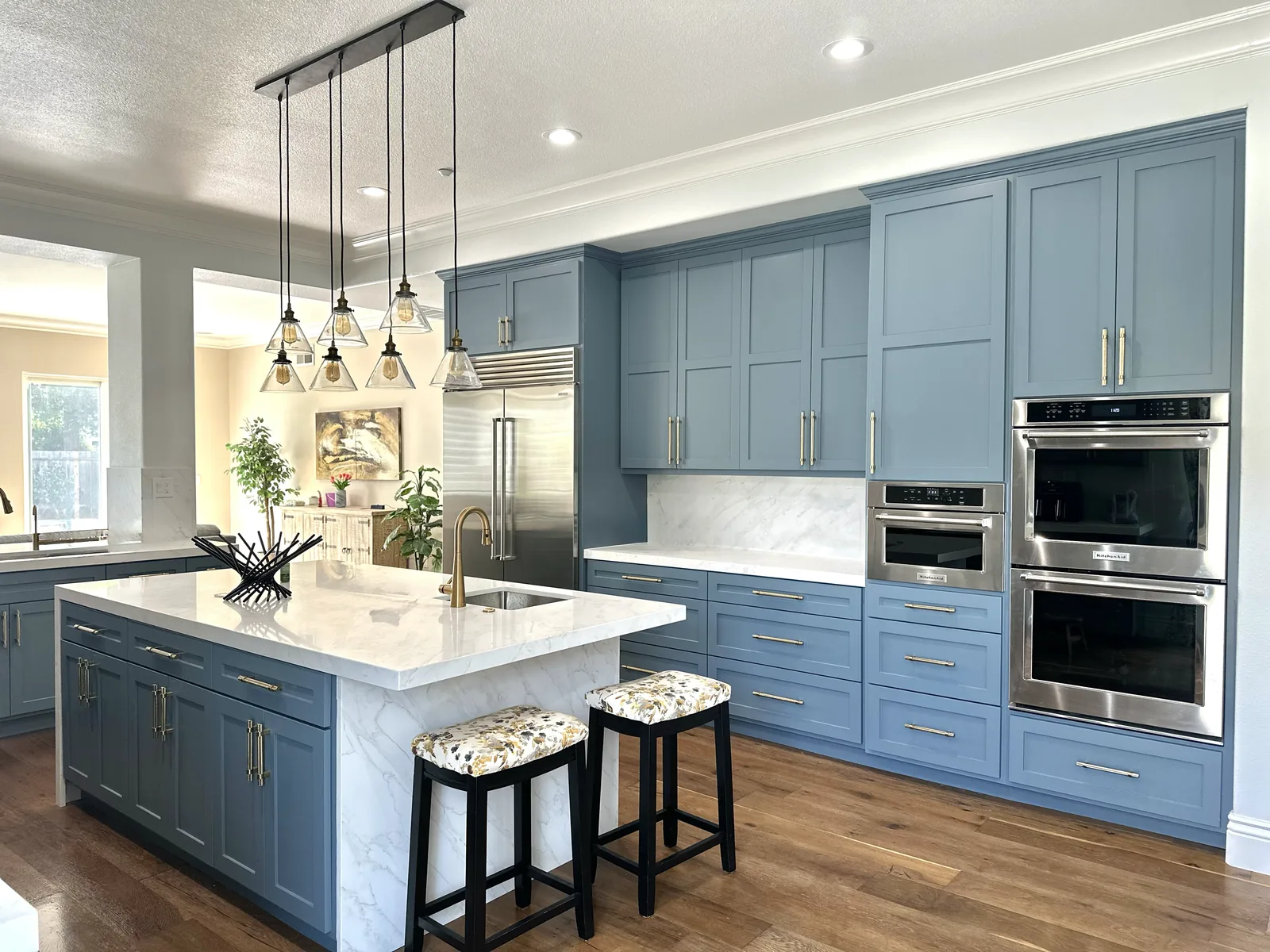 Blue grey shaker kitchen with brass hardware and a marble island in Morgan Hill