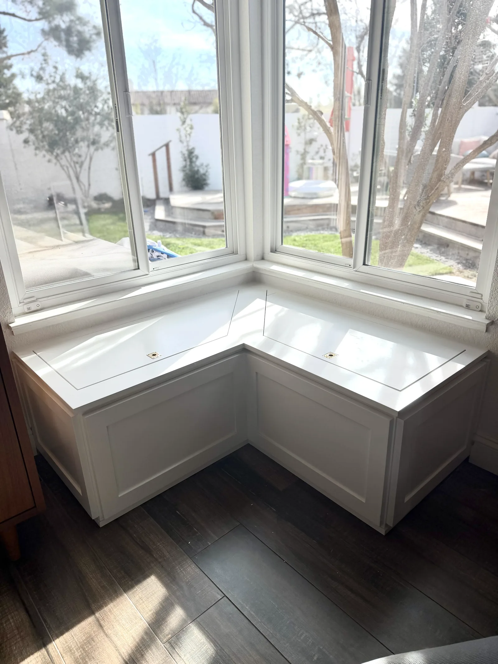 White built-in corner bench seating wrapping a window in Morgan Hill
