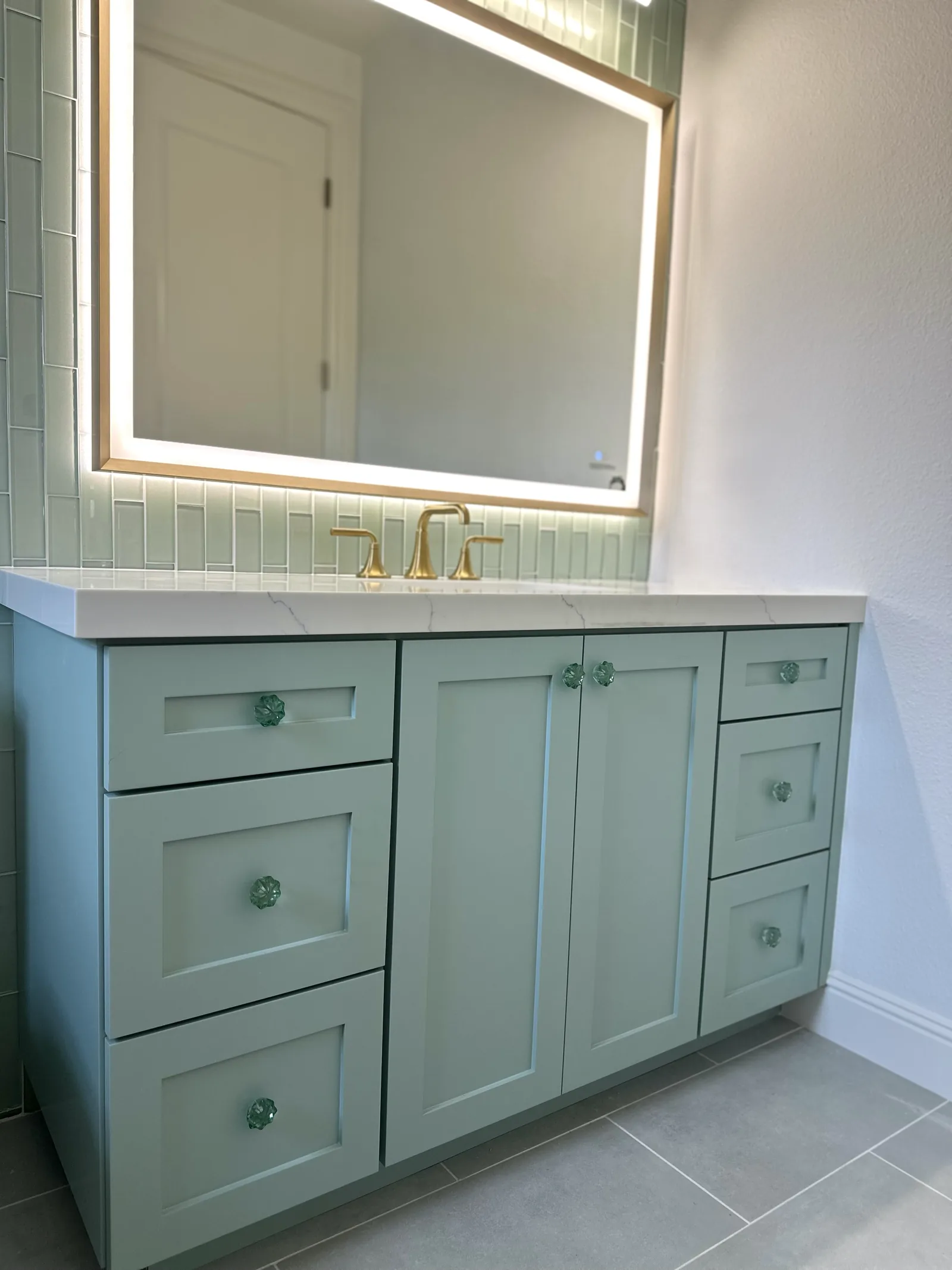 Sage green shaker vanity with glass knobs and a quartz top in Morgan Hill