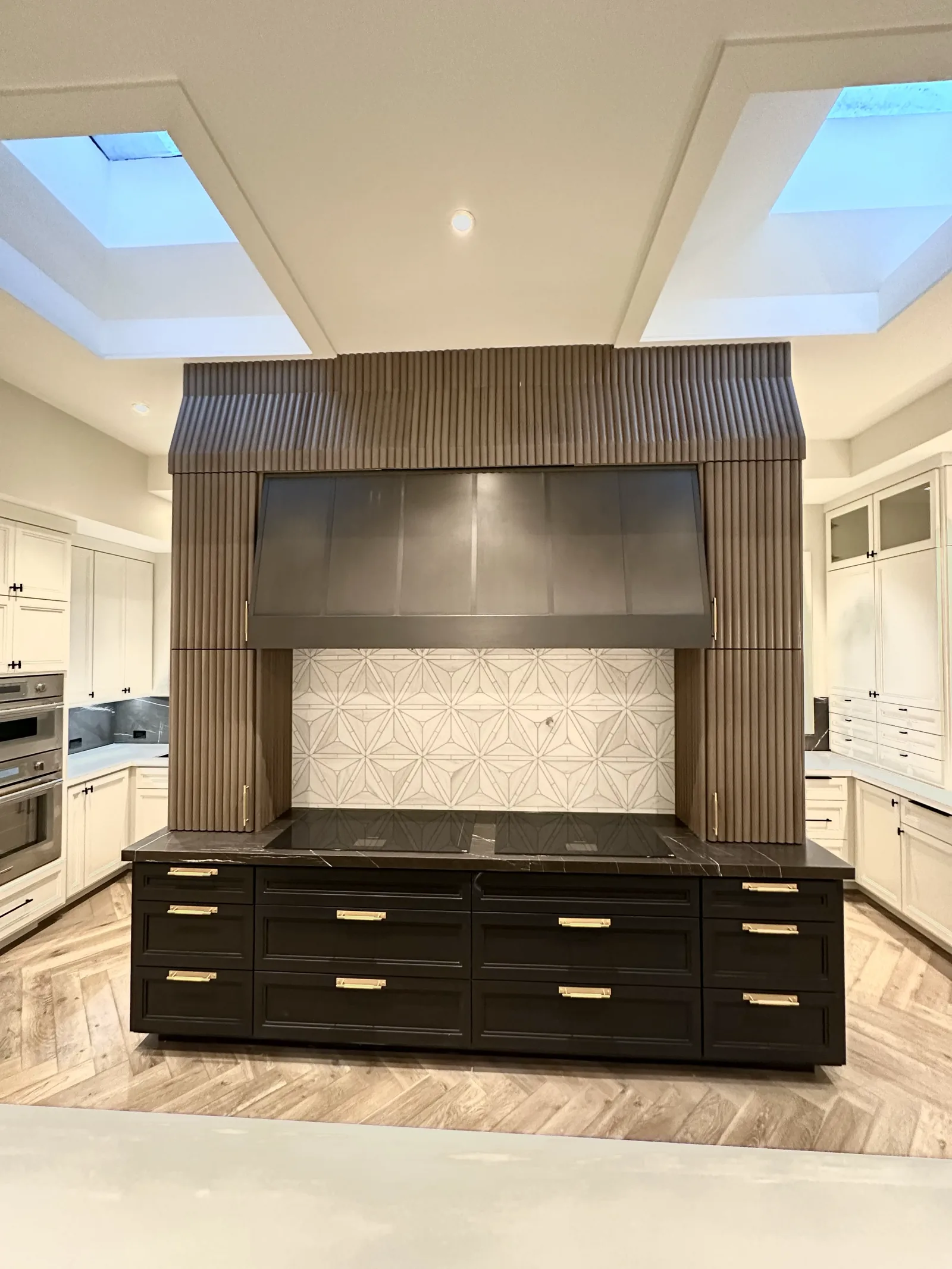 White kitchen with a dark fluted island and matching range hood in Palo Alto