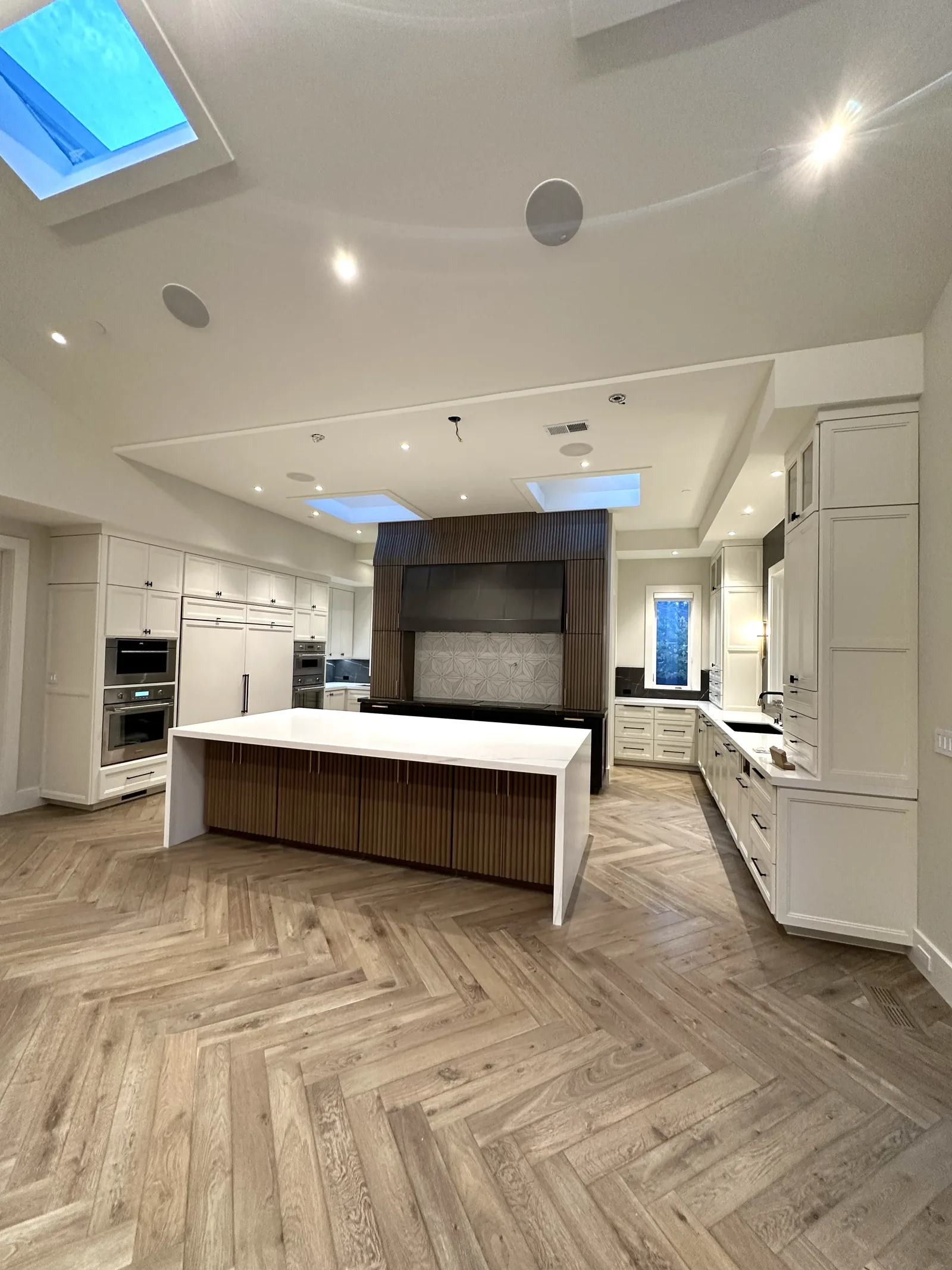 White painted kitchen with a fluted hood and herringbone floor in Palo Alto