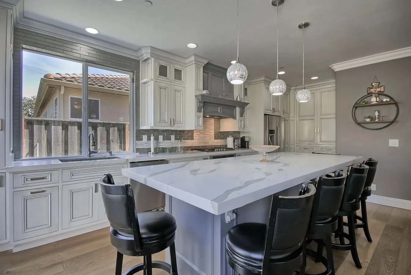 White and grey kitchen with a large quartz island and seating in Salinas