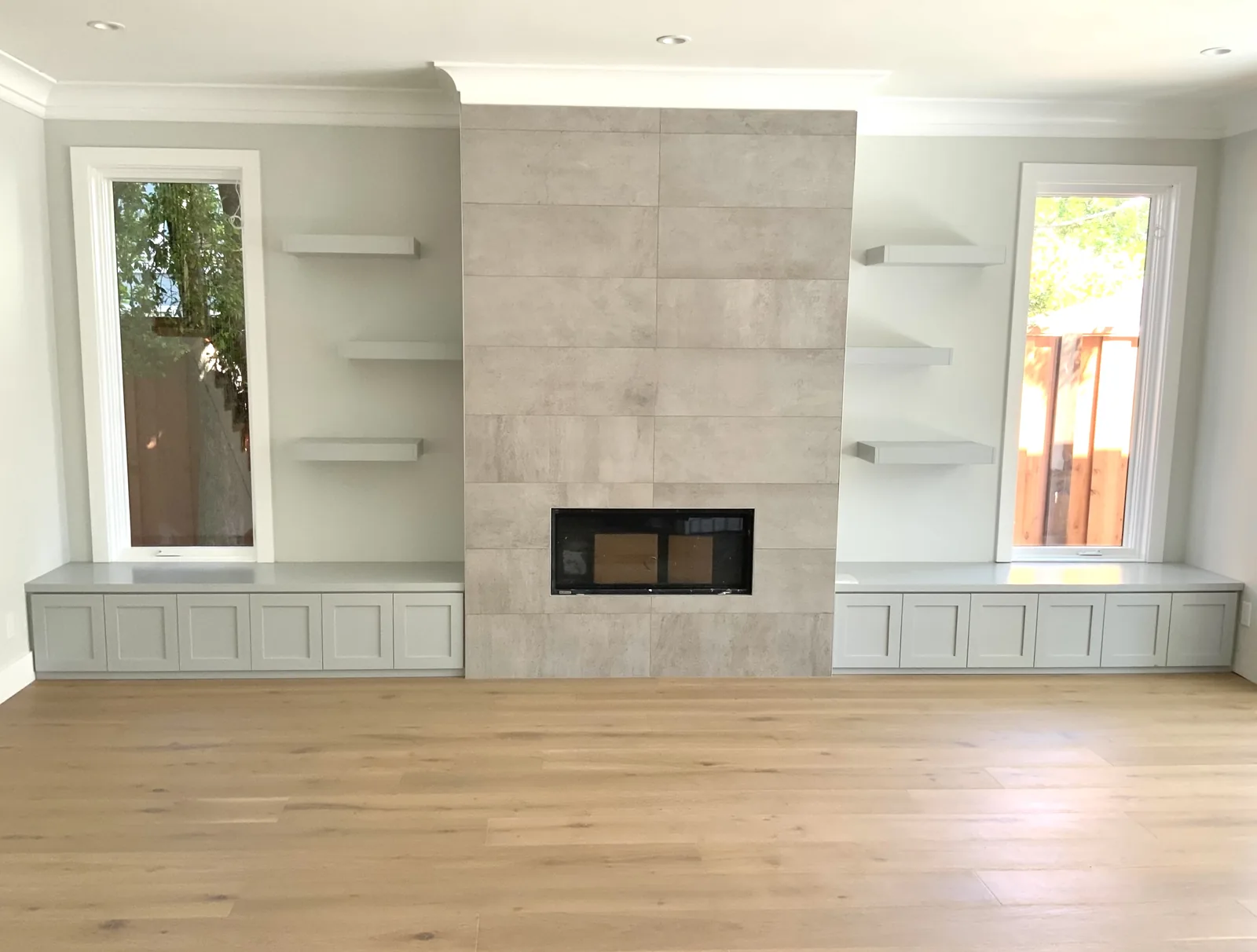 Tiled fireplace with built-in window benches and floating shelves in San Jose