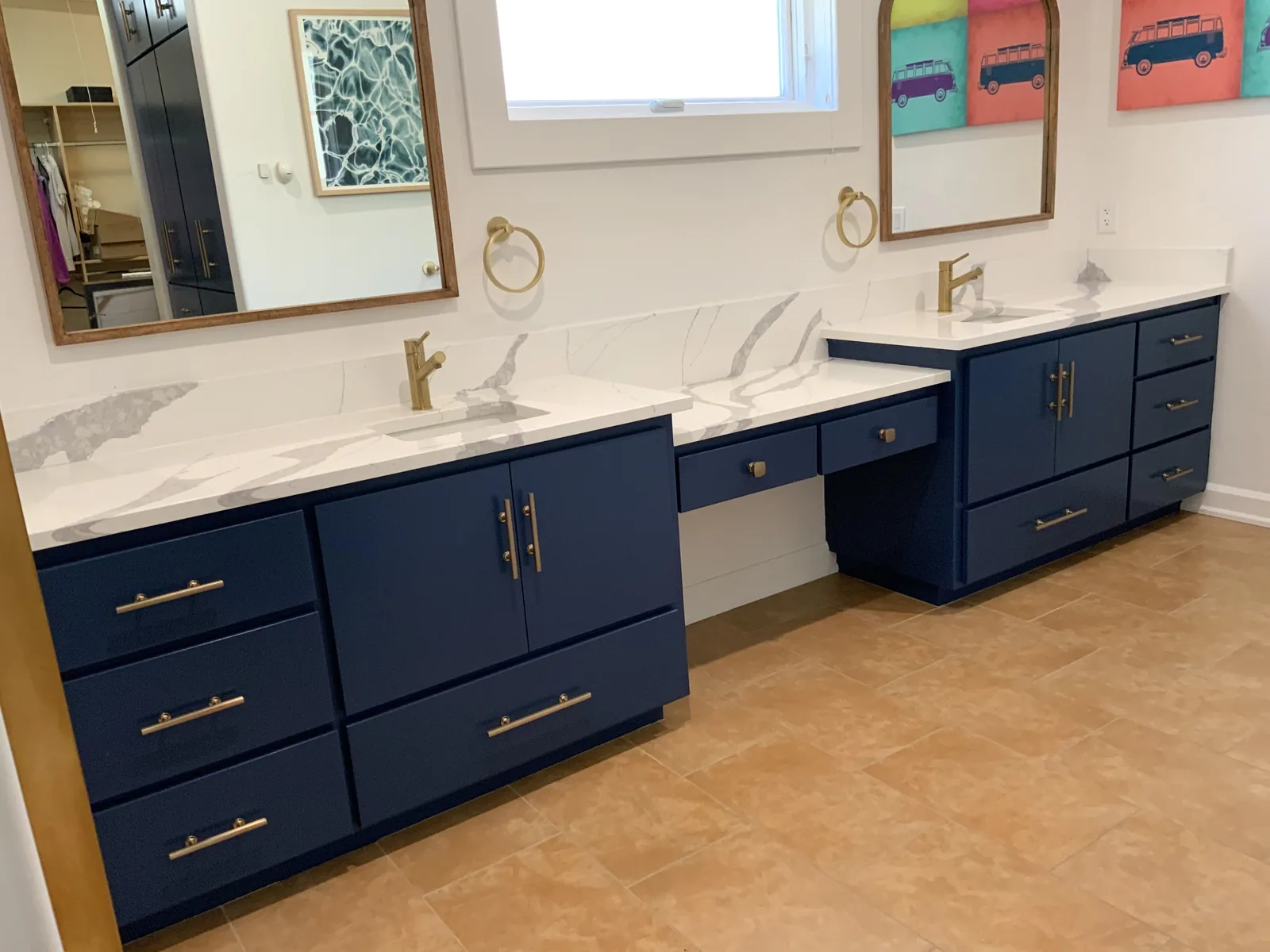Navy double vanity with a seated makeup station and brass hardware in San Jose