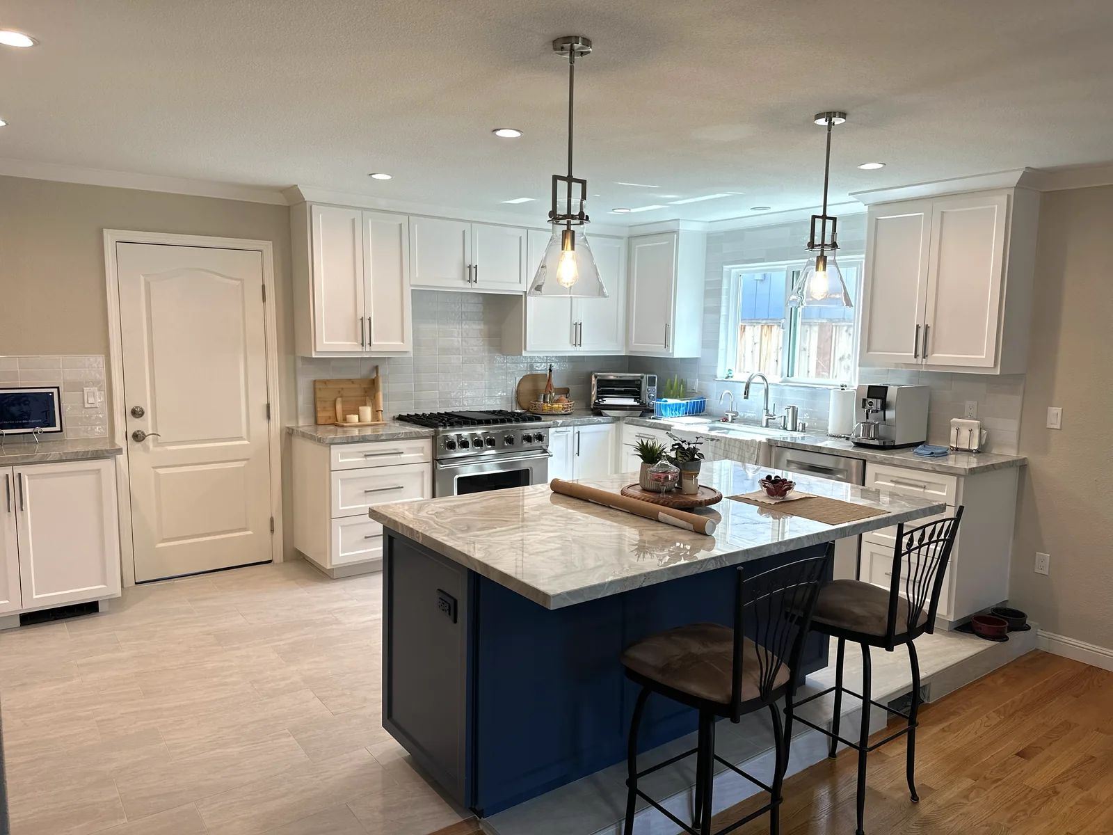 White shaker kitchen with a navy island and granite counters in San Jose