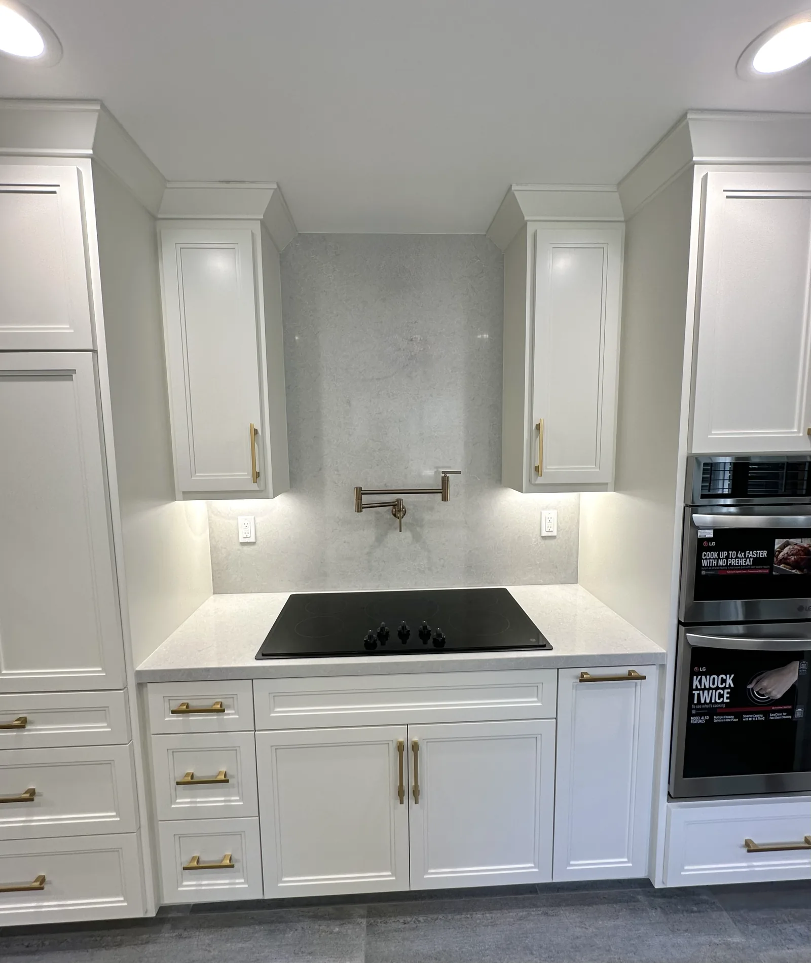 White kitchen with a cooktop run and stacked ovens in Santa Clara