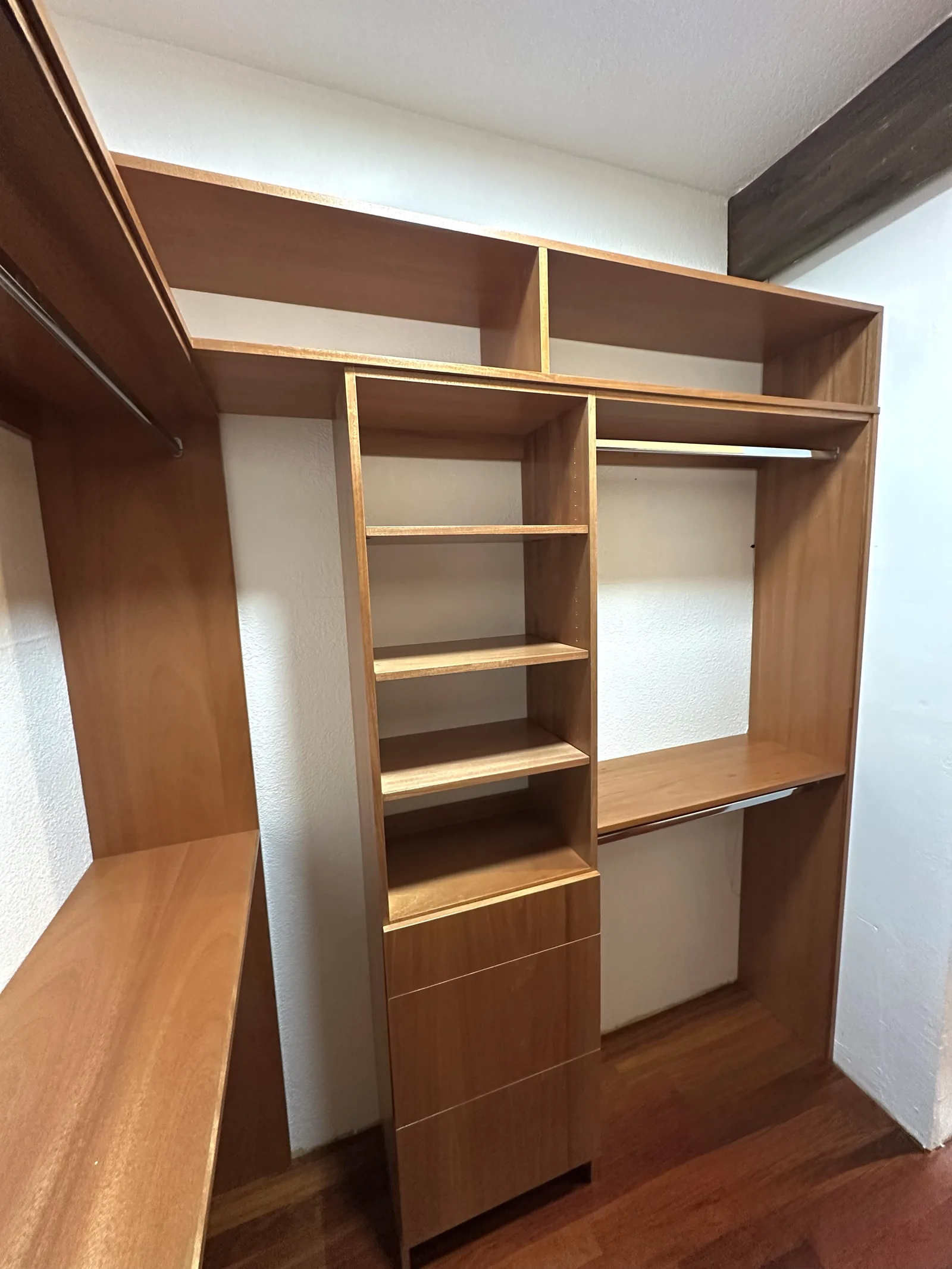 Custom walk-in closet with hanging runs, shelving and a built-in desk in Scotts Valley
