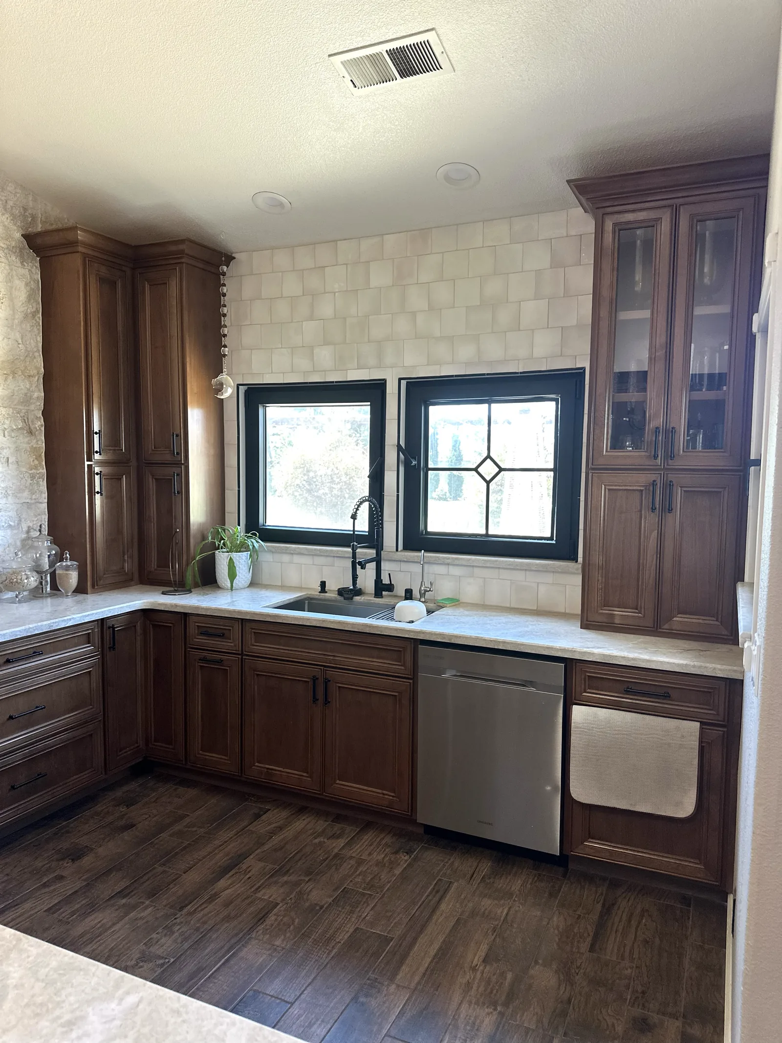Dark stained raised panel kitchen with glass front uppers in Soledad