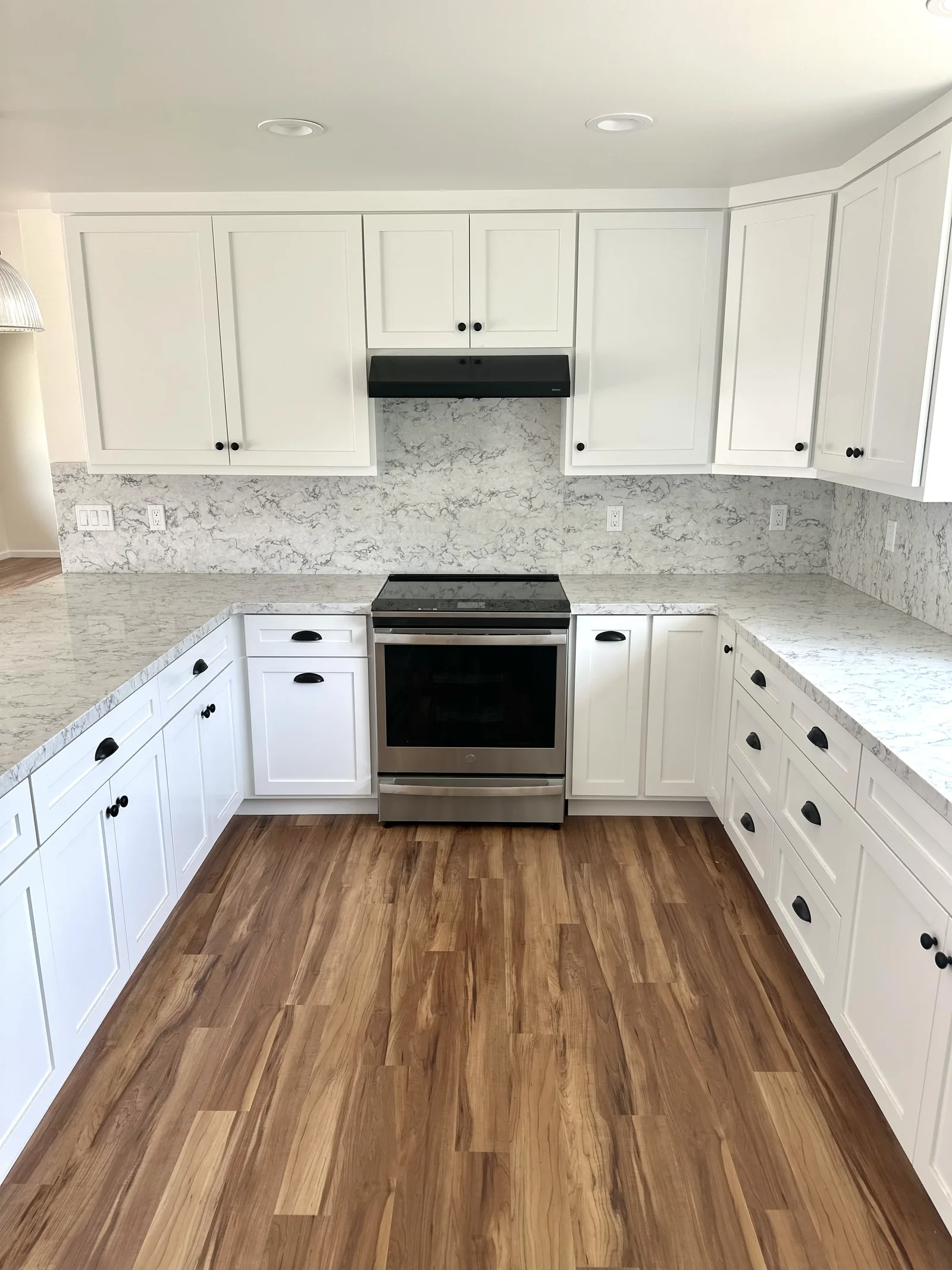 White shaker kitchen in a U-shaped layout with quartz counters in Soquel